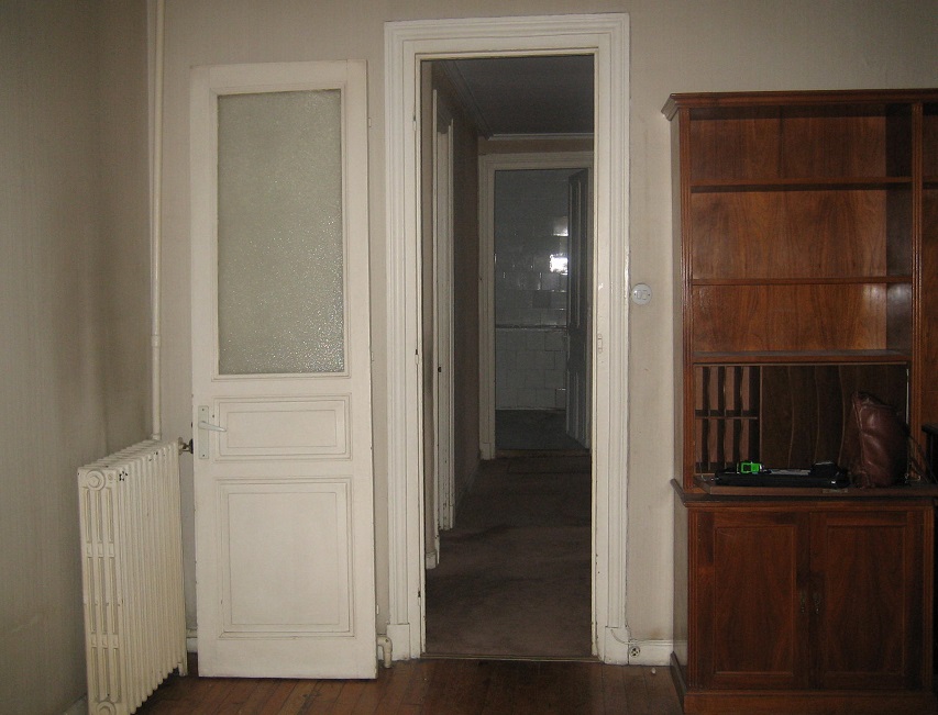 Vista de estancia antigua con puertas blancas, suelos de madera y mueble oscuro antes de reforma con criterios de ecodiseño por Ane Valverde Interiorismo en Donostia - San Sebastián